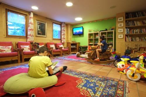 a child sitting on the floor in a living room at Hotel Granta Parey in Rhêmes-Notre-Dame