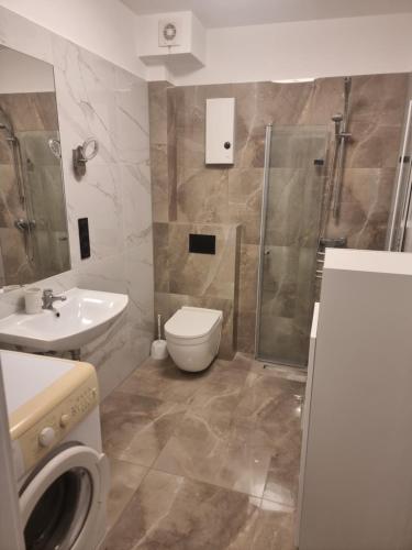 a bathroom with a toilet and a sink and a shower at Apartament Morskie Oko in Międzyzdroje