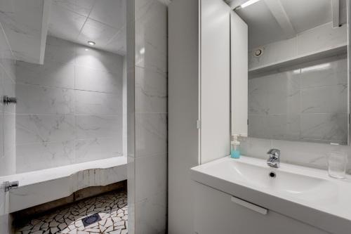 uma casa de banho branca com um lavatório e um espelho em Spacieux 90m2 Jacuzzi, Standing,Bien-être em Toulouse