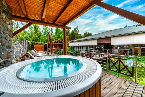 a hot tub on the deck of a house at Kontakt Wellness Hotel in Tatranská Lomnica