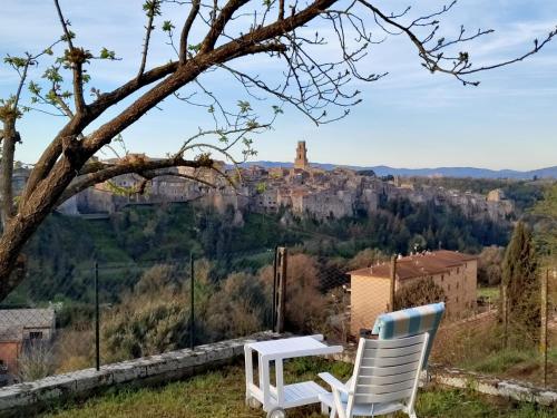 two chairs and a table with a view of a castle at IL NIDO DEL FALCO in Pitigliano
