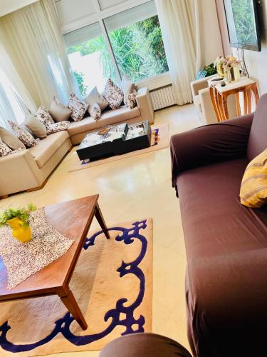 a living room with a couch and a table at Belle villa avec jardin Ennacer in Ariana