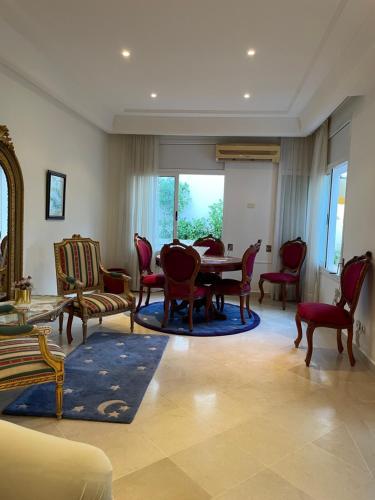 a living room with a table and chairs at Belle villa avec jardin Ennacer in Ariana
