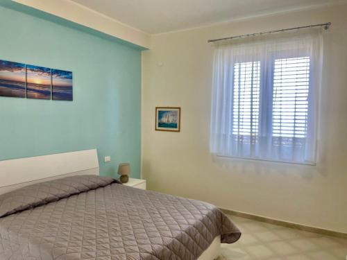 a bedroom with a bed and a window at Le finestre sul mare in Santa Flavia