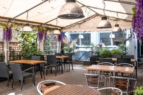 a patio with tables and chairs and purple flowers at The Beaufort Hotel in Chepstow