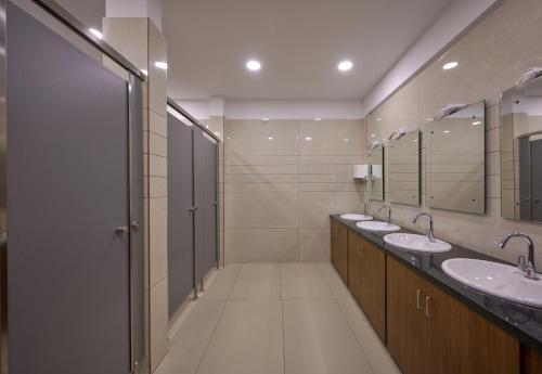 a bathroom with two sinks and two mirrors at Tiger Trails Thekkady in Thekkady