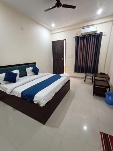 a bedroom with a large bed with blue pillows at Hotel JP Inn in Lucknow