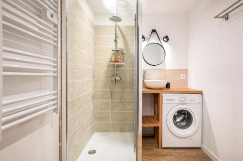 a bathroom with a shower and a washing machine at Nationale 202 CahorsCityStay in Cahors