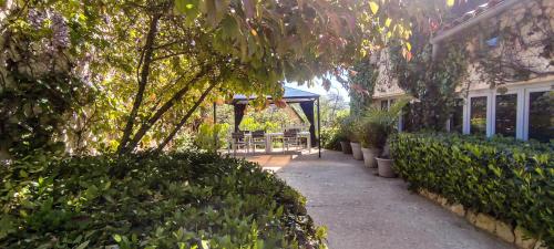 a porch of a house with a bench and trees at La Source in Saint-Cybranet