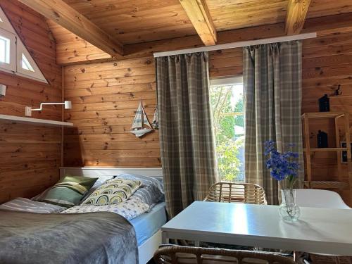 a bedroom with a bed and a table in a room at Ustka- Wakacyjny Domek Letni Wiatr in Ustka