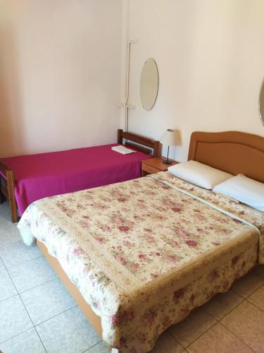 Habitación de hotel con 2 camas y espejo en Anestis Apartments & rooms, en Palaión Tsiflíkion