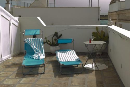 two blue chairs and a table on a balcony at Suite Dolce Vita in Monopoli