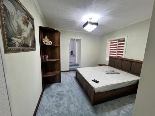 a bedroom with a bed and a picture on the wall at STS-Family home guest house in Samarkand