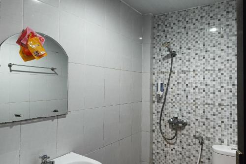 a bathroom with a shower and a toilet at OYO 93929 Erbee Inn in Makassar