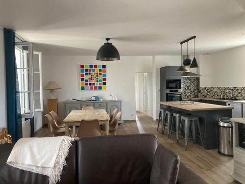 un salon avec une table et une cuisine dans l'établissement L'Appartement du Comptoir, à Saint-Genès-de-Castillon