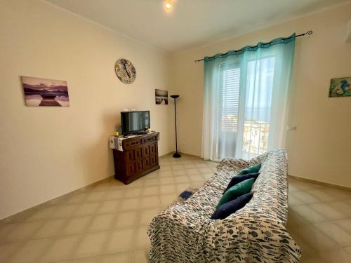 a living room with a couch in front of a window at Le finestre sul mare in Santa Flavia