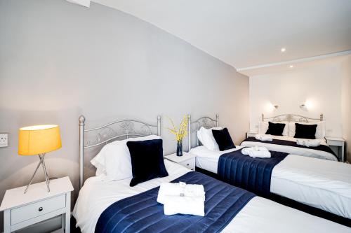 a bedroom with two beds and a lamp in it at The Beaufort Hotel in Chepstow