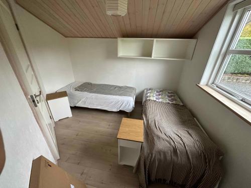 FårvangにあるLuxury House, Spa-sauna, Pool, Carcharger, Riverのベッドと窓が備わる小さな客室です。