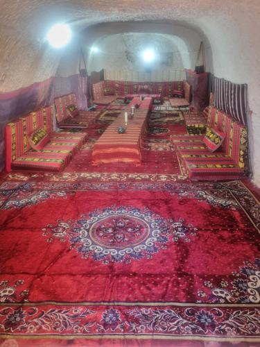TūjānにあるMaison d'hôte dar massouadaの広い客室で、床に赤い敷物が備わります。