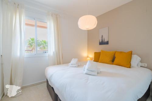 1 dormitorio con 1 cama blanca grande con almohadas amarillas en Zafiro, en Calpe