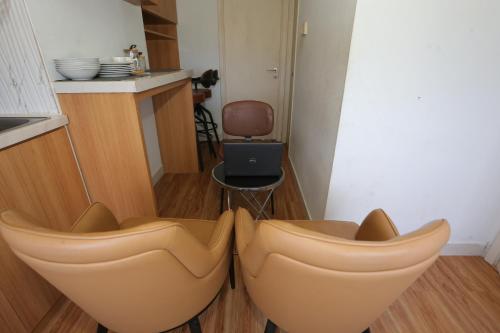 une chambre avec deux chaises et une cuisine avec une table dans l'établissement OYO 93933 King's Room, à Bekasi