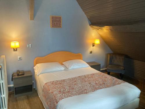 een slaapkamer met een bed en een stoel erin bij Hotel Le Bon Laboureur in La Charité-sur-Loire