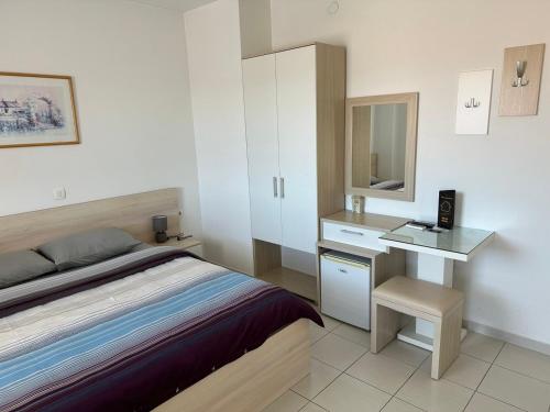 a bedroom with a bed and a desk with a mirror at Villa Jankuloski in Ohrid
