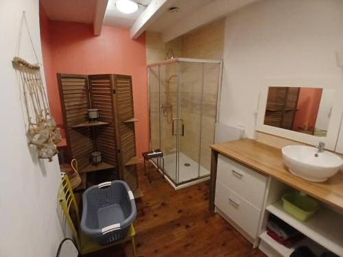 a bathroom with a sink and a glass shower at charmante maison de village renovée in Bazoges-en-Pareds