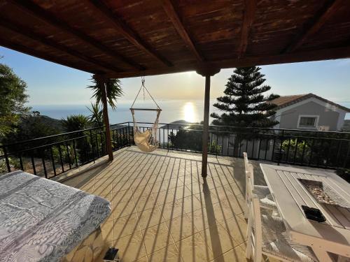 a porch with a hammock and a view of the ocean at Vigla Villas in Volímai