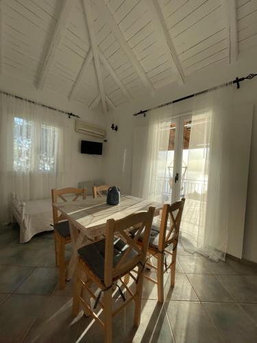 a dining room with a wooden table and chairs at Vigla Villas in Volímai