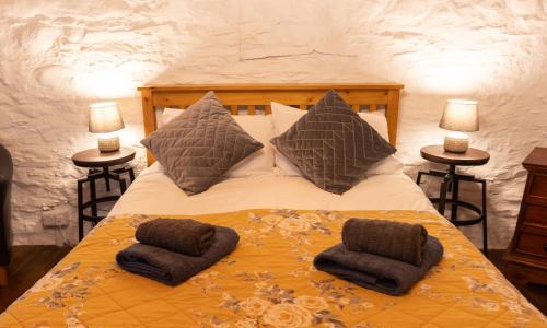 a bedroom with a bed with two pillows on it at Deer House in Machynlleth