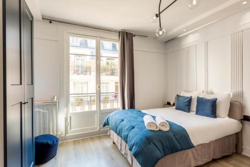 une chambre avec un lit avec deux pantoufles dessus dans l'établissement Square Villaret Studio, à Paris