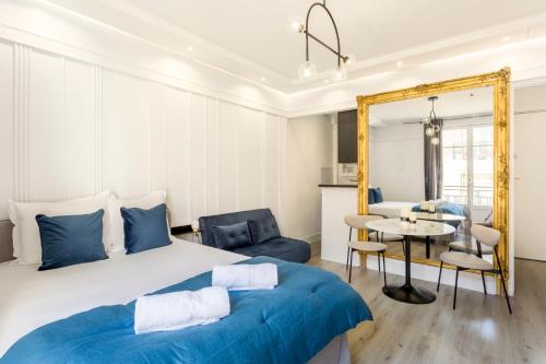 une chambre avec un grand lit et une table dans l'établissement Square Villaret Studio, à Paris