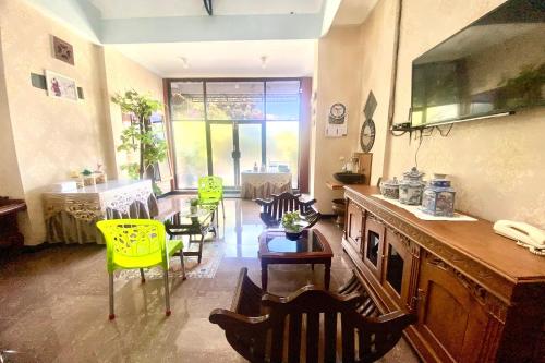 a living room with yellow chairs and a table at Capital O 93942 Griya Singgah Berkah Syariah in Purworejo