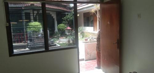 SPOT ON 93943 Sakinah Homestay Bromo Syariah في مالانغ: باب مفتوح لحديقة خارج المنزل