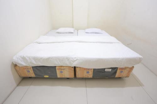 a bed sitting on top of two boxes in a room at SPOT ON 93827 Rumah Kost Harapan Indah in Bekasi