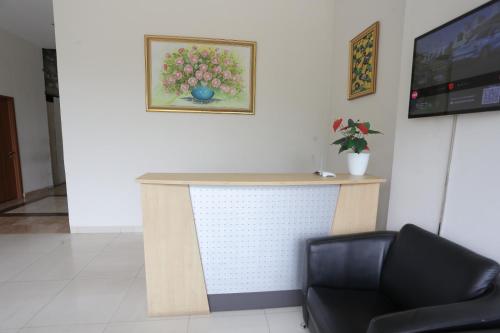 een bureau in een kamer met een stoel en een televisie bij OYO 93948 Bunda Rachma Rooms in Parungmalela
