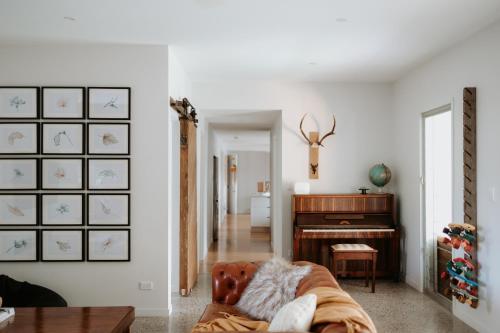 a living room with a couch and a piano at Gorgeous 5 bedroom beach house. Dog/Kid Friendly. in Marcoola