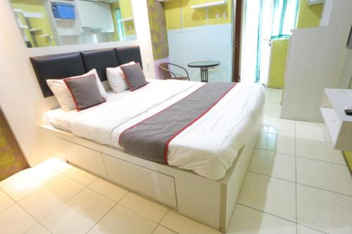 A bed or beds in a room at Capital O 93910 Asia Rooms @ Green Lake View Ciputat
