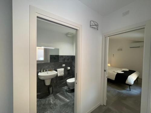a bathroom with a sink and a toilet and a bed at CaVecchie Desenzano in Desenzano del Garda