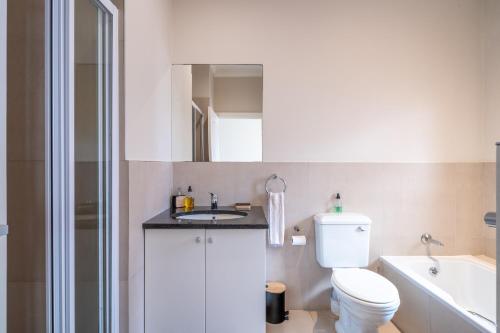 a white bathroom with a toilet and a sink at Luxury , space and views - Pezula Villa 13 in Knysna