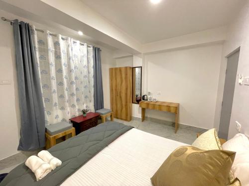 - une chambre avec un grand lit et une fenêtre dans l'établissement Ga-Ki-Khim Homestay, à Gangtok