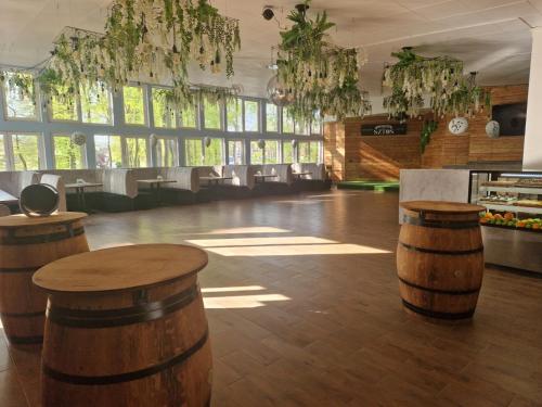 a large room with wooden stools in a room with windows at OW Gromada Pod Bukami in Międzyzdroje