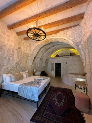 a bedroom with a large bed and a bath tub at Ortahisar Cave Hotel in Ortahisar