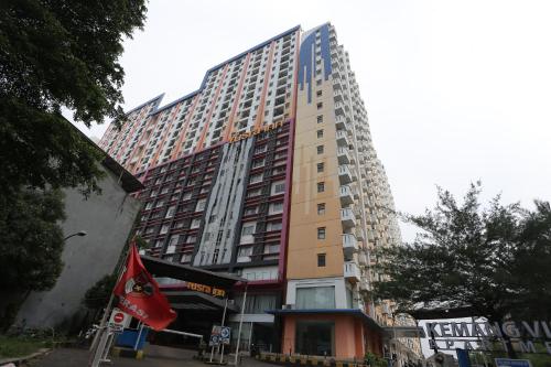 un edificio alto con una bandera delante de él en OYO 93952 Dms Property, en Bekasi