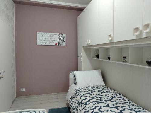 a bedroom with a bed and a picture on the wall at Appartamento Mari Mari in Casale Monferrato