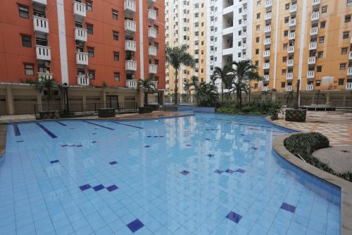 a large swimming pool in a building with tall buildings at OYO 93952 Dms Property in Bekasi