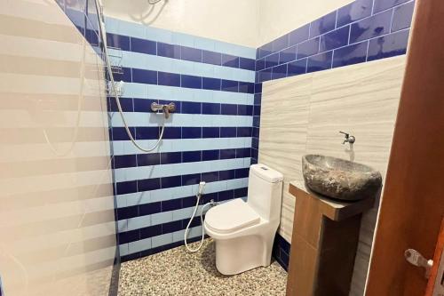 a bathroom with a toilet and a sink at Belvilla 93954 Meta Pandawa Bali Mounth Villa in Jembrana