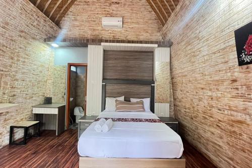 una camera con un grande letto in un muro di mattoni di Belvilla 93954 Meta Pandawa Bali Mounth Villa a Jembrana