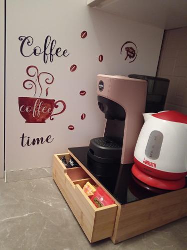 a coffee maker on a counter with a coffee time wall at Appartamento Mari Mari in Casale Monferrato